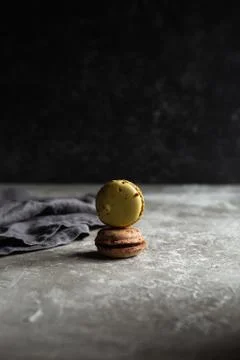 Two macarons are in a stack on a dark background Stock Photos