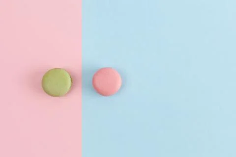 Two macarons on divided background in pastel colors. Top view with copy space Stock Photos
