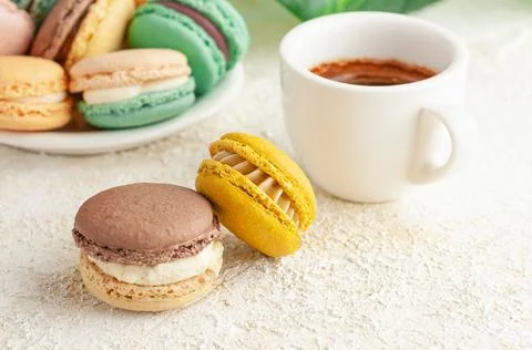 Two macaroons are on the table. In the background, cups with coffee. And plat Stock Photos