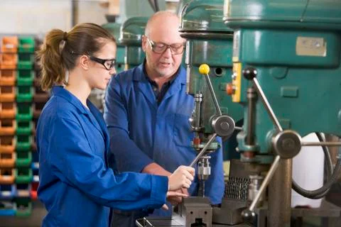Two machinists working on machine Stock Photos