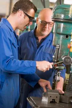 Two machinists working on machine Stock Photos
