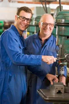 Two machinists working on machine Stock Photos
