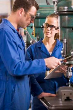Two machinists working on machine Stock Photos