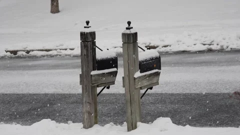 Two mail boxes on wooden poles covered in fresh winter snow Stock Footage 152892238