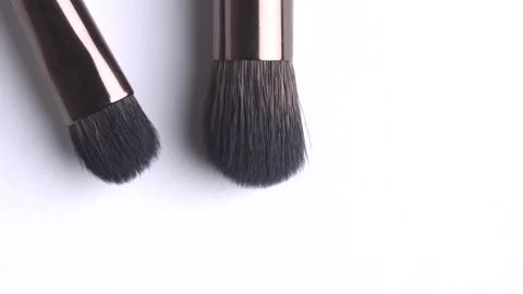 Two makeup brush rotates on a white background. Close up of several makeup .. Stock Footage 268844942