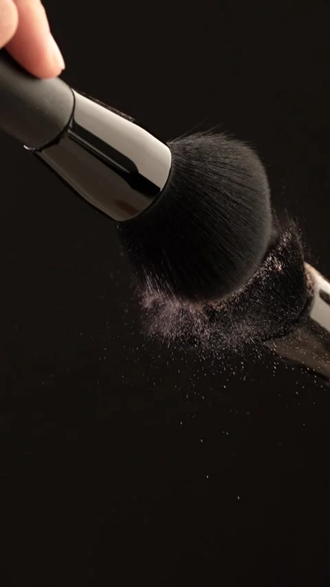 Two makeup brushes collide softly in slow motion, releasing powder, blush a.. Stock Footage 312762647