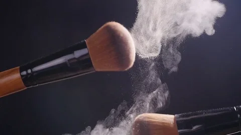 Two makeup brushes with powder on a dark background Stock Footage 80303101