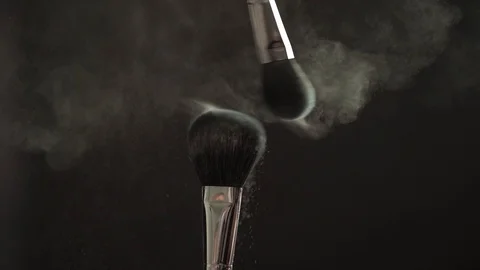 Two makeup brushes with powder on a dark background, slow motion Stock Footage 104502195
