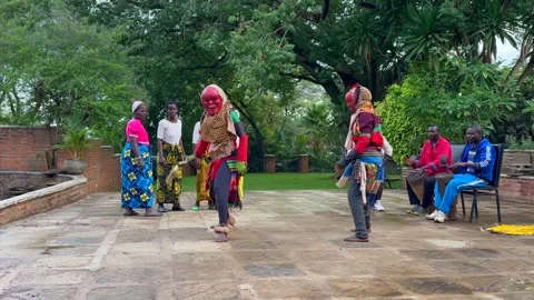 Two Malawian men in masks and in colorful clothes performing a traditional Stock Footage 334412072