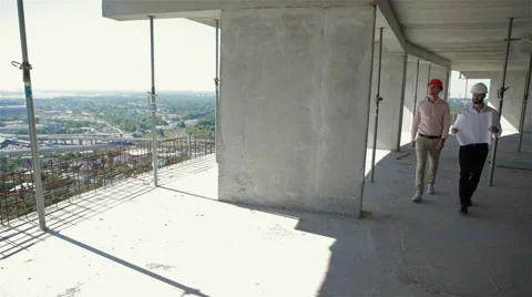 Two male builders walking through the building under construction Stock Footage