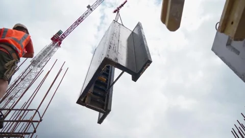 Two male construction workers installing a concrete slab. Tower crane Stock Footage 278236718
