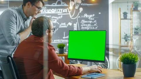 Two Male Developer Talk about Project Computer Has Green Mock-Up Screen Template 写真素材