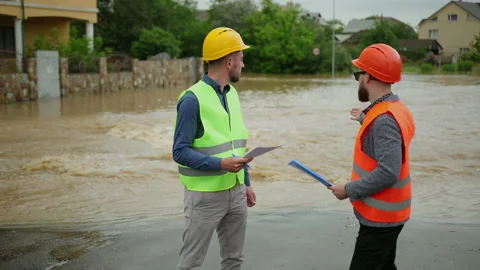 Two male engineers solve the flood problem. Natural disaster major flooding Видео 135384143