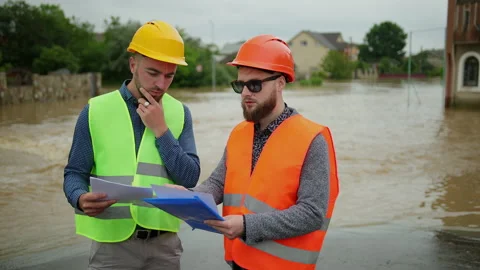 Two male engineers solve the flood problem. Natural disaster major flooding Vidéo 135384390