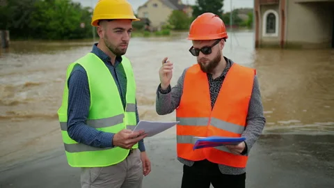 Two male engineers solve the flood problem. Natural disaster major flooding Vidéo 135430771