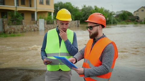 Two male engineers solve the flood problem. Natural disaster major flooding Video stock 135430854