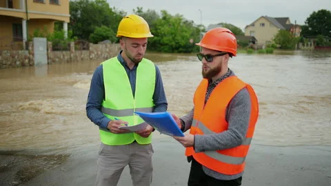 Two male engineers solve the flood problem. Natural disaster major flooding Stock-Footage 137645968