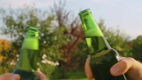 Two male hands clinking bottles of beer Stock Footage 138276100