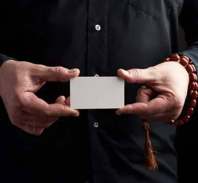 Two male hands holding a rectangular blank white paper business card, a man w 写真素材