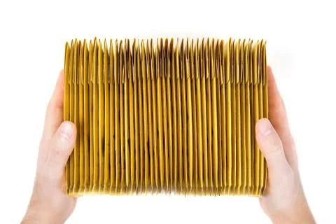 Two male hands holding a stack of yellow shipping envelopes. Top view. Foto stock
