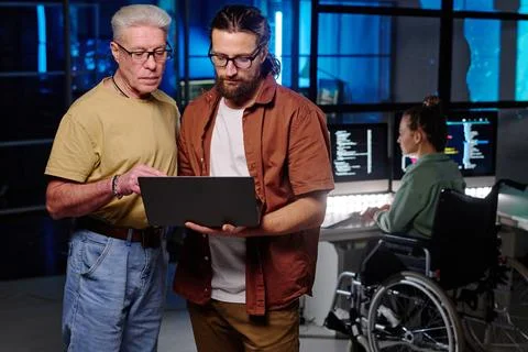 Two male It managers looking at laptop screen during presentation Stock Photos
