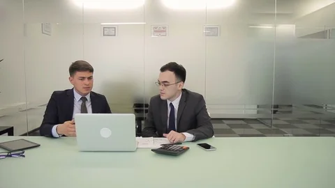 The two male managers discuss the report in co-working room with glass wall. Stock Footage 85373907