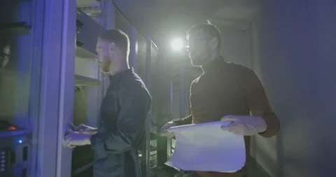 Two male network administrators try to resolve problem in work of server 스톡 동영상 107339904