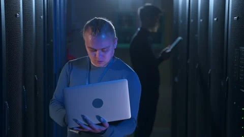 Two male programmers working with laptop and tablet, checking equipment at Stock Footage 165196430