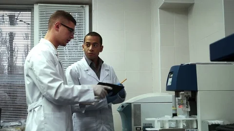 Two Male Scientists Working on Laboratory Test Machine Together Stock Footage 71781508