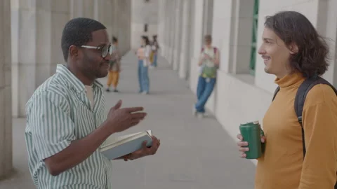 Two Male Students Standing Outside University and Having Talk Stock Footage 267232196