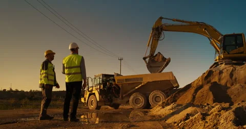 Two Male Workers Discussing Project On Construction Site Stock Footage 256041830