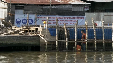 Two male workers of pier construction on the riverside of Martapura river Stock Footage 136963678