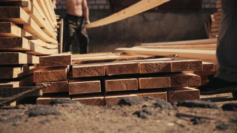 Two male workers stacking long wooden timber boards for drying outdoors 스톡 동영상 207412348
