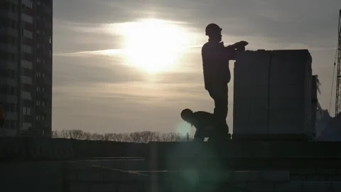 Two male workers in a sunset on a construction site Stock Footage 248206234