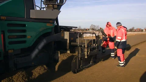 Two male workers is working on the construction of a new road. Special machine Stock Footage 94486628