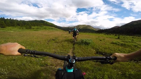 Two Males And Two Female Cyclists Riding  In An Alpine Meadow Video stock 115098366