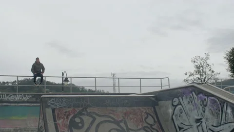 Two males jump and spin at skatepark Stock Footage 171491513