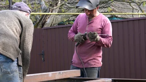 Two males prepaerd for work day, man in red shirt and protactive mask inserts an Stock Footage 131117981