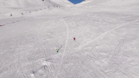 Two males riding ski and snowboard from mountains slope in slowmotion Stock Footage
