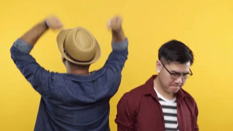 Two man are friend put on hat and glasses dancing isolated on yellow background. Stock Footage 144663692