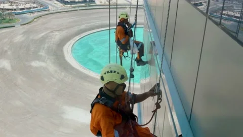 Two man cleaning windows of the building from outside Stock Footage 136048954
