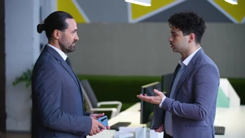 Two man employees in suits are talking in the office Video stock 233716901