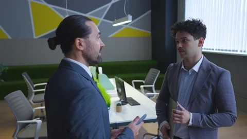 Two man employees in suits are talking in the office, a boss and a worker Stock Footage 233994906