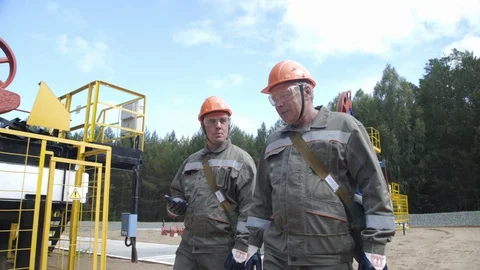 Two man oil workers walking and talking near oil pump jacks. Oil engineers Vídeo Stock 127659637