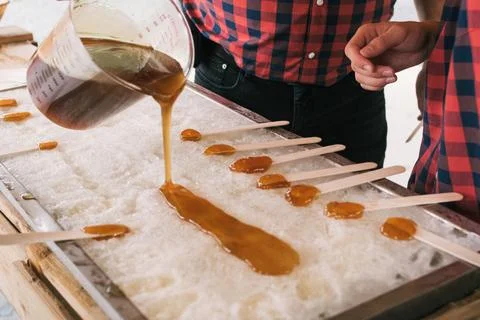 Two man pouring maple syrup on ice Foto stock