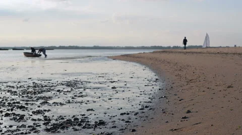 Two man pushing a small boat into water from the sand 4K Stock Footage 55225410