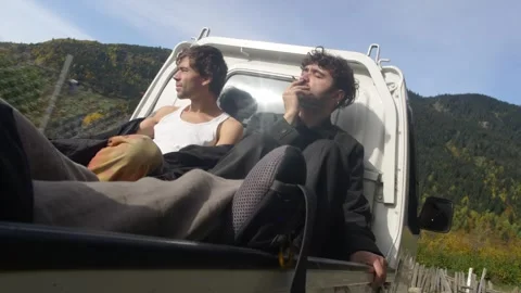 Two man Riding In Back Of Pick Up Truck in the countryside among the mountains Stockbeeldmateriaal 271676949