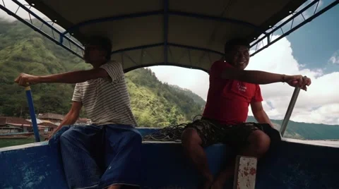 Two man rowing in a boat on Lake Batur on the way to Trunyan cemetery, editorial Stock Footage 64282768