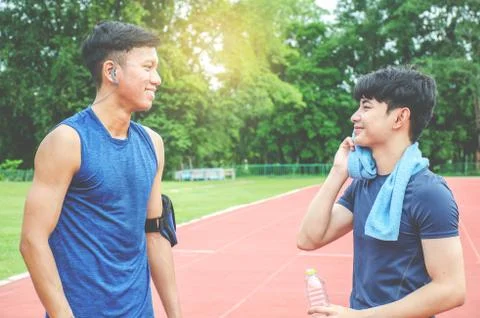 Two Man runners standing talking after running and training exercise in stadium Stock Photos
