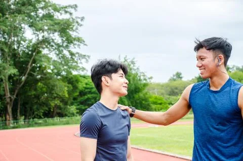 Two Man runners standing talking after running and training exercise in stadium Foto stock